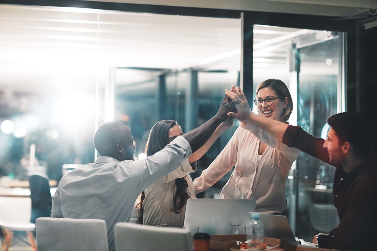 Bankers giving each other a high five during a meeting